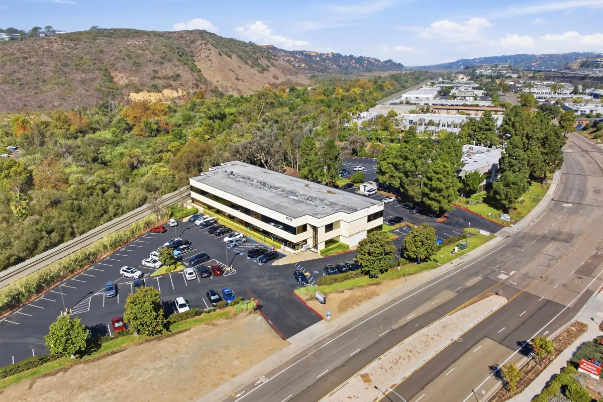 An aerial view of the office building and its parking lot, set against the hillside and canyon of Sorrento Valley